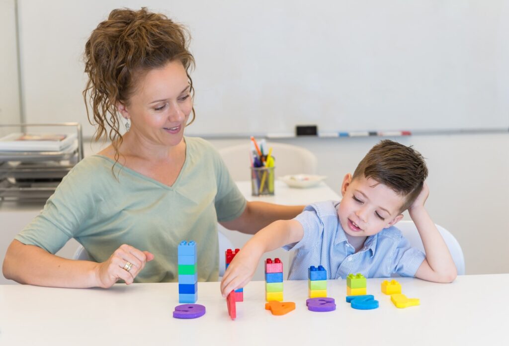 Autistic boy practicing numbers and colors during therapy session