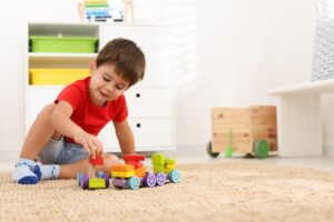 young child with autism playing with a toy train